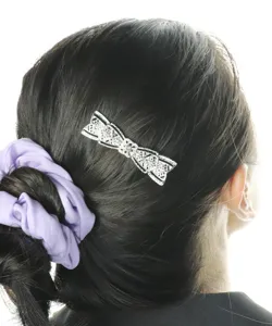 Detailed view of exquisite silver bow hair clip with sparkling rhinestones, vintage style.