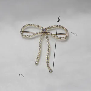 Detailansicht einer goldenen Vintage Strass Schleife Brosche mit funkelnden Kristallsteinen.