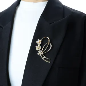 Detailed shot of a pearl flower brooch on a black blazer, elegant gold-tone metal suit accessory.