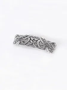 Close-up detail of vintage silver alloy hair barrette with intricate carved geometric pattern.