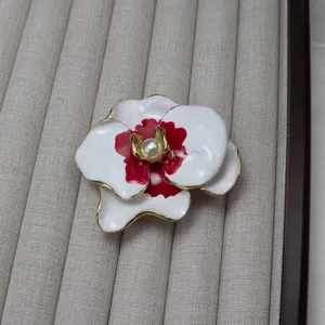 Exquisite vintage enamel phalaenopsis flower brooch with a central pearl and gold trim detail.