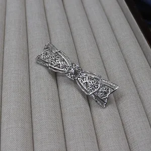 Vintage silver bow hair clip detail, elegant hollowed metal hair accessory for women.
