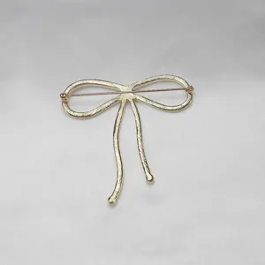 Goldfarbene Schleife Brosche Nadel Rückseite Detail elegante Mode Accessoire Damenkleidung