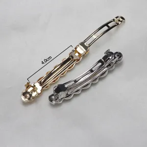 Close-up detail of small metal hair clips in gold and silver with a twisted wave design.