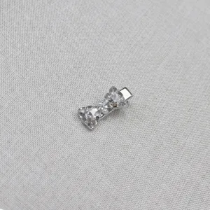 Silver tone bow hair clip detail view with sparkling crystals and tiny pearl accents.