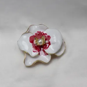Elegant vintage enamel white and red flower brooch with a central pearl, gold-edged design.