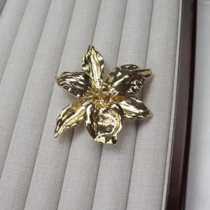 Gold metallic flower brooch detail, featuring a unique 3D petal design for chic outfits.