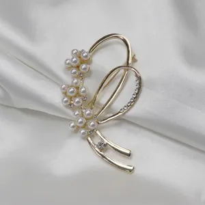 Detailed close-up shot of elegant gold pearl rhinestone brooch, fine craftsmanship accessory view.