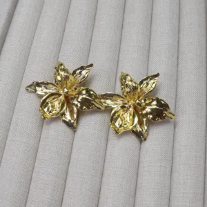Close-up detail shot of exquisite gold metallic floral jewelry, elegant texture and shiny finish.