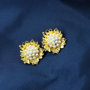 Détail boucles d'oreilles perles fleur or vintage, bijou floral élégant et raffiné.