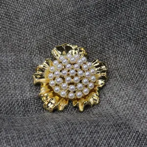 Détail de broche perle fleur or vintage, accessoire de bijoux floral élégant pour femmes.