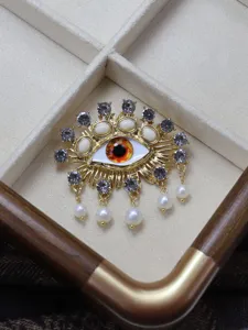 Detailed close-up shot of an intricate evil eye brooch featuring sparkling rhinestones and pearls.