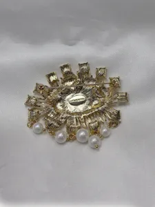 Reverse view of gold-tone fashion brooch with secure pin clasp and delicate hanging pearl drops.
