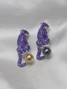 Detail view of stunning rhinestone encrusted panther brooch featuring a lovely pearl accent.