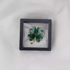 Pendentif broche trèfle à quatre feuilles vert exquis dans un boîtier d'affichage clair.