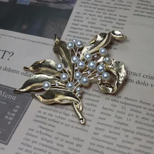 Vintage gold-tone flower leaf brooch with pearls and rhinestones statement jewelry accessory.