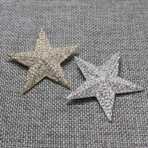 Detail shot of sparkling rhinestone star brooch pins in gold and silver, perfect accessories.