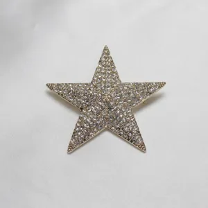 Close-up detail of a sparkling crystal rhinestone five-pointed star brooch fashion accessory.