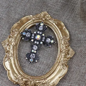 Vintage kristalen kruis broche detailopname met sprankelende strass steentjes op antiek zilver.