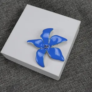 Closeup view of the blue enamel iris brooch showing exquisite petals and metal details.