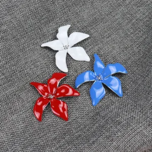 Enamel iris flower brooch detail shot, showing colorful metal pin craft and delicate texture.
