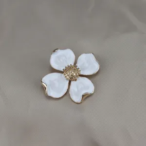 Vintage gold-rimmed white enamel four-petal flower brooch, elegant detail jewelry accessory.