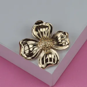 Vintage gold tone metallic four petal flower brooch, detailed textured petal jewelry accessory.