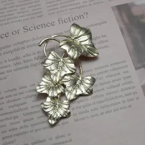 Vintage gold-tone grape leaf brooch pin, elegant clothing accessory for women and daily wear.