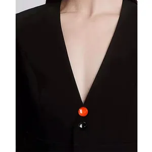 Close-up detail shot of magnetic brooch on black apparel neckline, elegant anti-glare design.