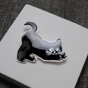 Spilla smaltata gatto nero, bordo argento con occhi blu, raffinato dettaglio accessorio.