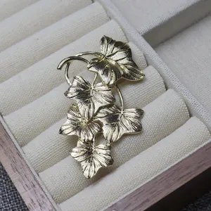 Detailed view of vintage gold-tone ivy leaf brooch, elegant retro clothing accessory gift.