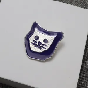 Dettaglio spilla gatto in smalto con bordo viola e viso argento testurizzato, finemente lavorata.
