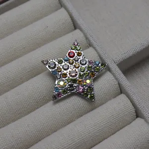 Gros plan d'une broche en strass en forme d'étoile à cinq branches aux pierres multicolores.