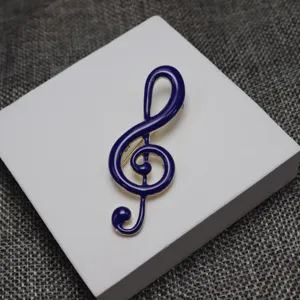 Enamel treble clef musical note brooch pin, elegant dark blue metal garment accessory.