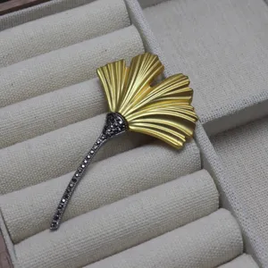 Vintage ginkgo leaf brooch detail view, matte gold finish with black pavé crystals.