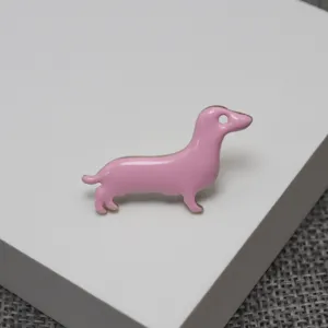 Cute pink dachshund enamel brooch detail shot, ideal for accessorizing bags and hats.