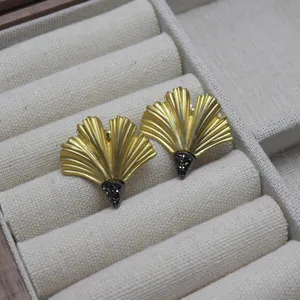 Vintage gold ginkgo leaf earrings with dark crystal accent, elegant fashion jewelry accessory.