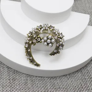 Vintage pearl rhinestone crescent moon flower brooch pin detailed shot, elegant gold tone accessory.