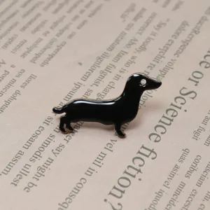 Close-up of cute black dachshund enamel pin detail, stylish lapel accessory on paper background.