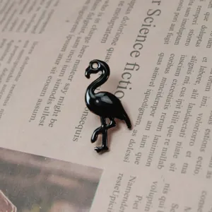 Broche flamant rose en émail noir, accessoire élégant en métal pour vêtements et chapeaux.