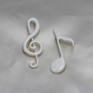 Handmade white enamel music note brooch, elegant gold-trimmed apparel accessory for daily wear.
