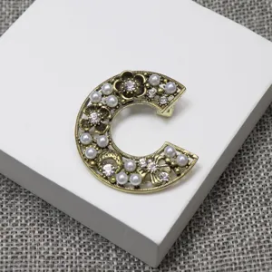 Exquisite vintage style C letter pearl rhinestone brooch detail shot for chic wear.