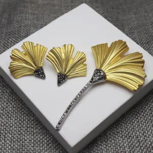 Vintage matte gold ginkgo leaf brooch and earrings jewelry set with sparkling crystal details.