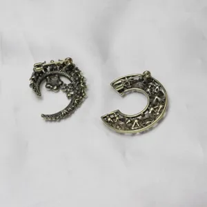 Detailed back view of vintage gold-plated moon and letter C rhinestone brooch pins.