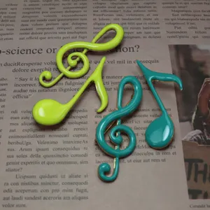 Enamel music note brooch detail shot, creative musical accessory in vibrant colors.