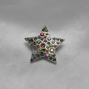 Gros plan détaillé d'une broche élégante en forme d'étoile ornée de cristaux scintillants.
