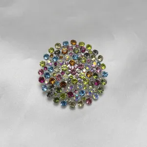 Vue de détail d'une broche ronde scintillante avec des strass colorés sur satin.