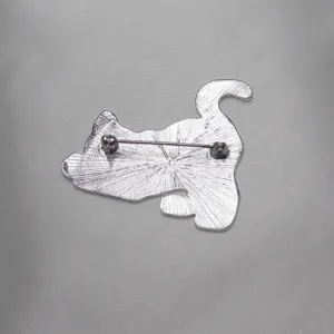 Vista posteriore dettagliata di una spilla a forma di gatto in metallo argentato con chiusura.