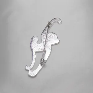 Dettaglio del retro della spilla animale in metallo argentato, chiusura sicura, accessorio.