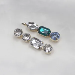 Close-up detail of colorful rhinestone bobby pins with sparkling crystal stones on gold base.